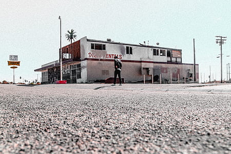 photo of man standing on road near building thumbnail