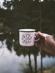 person holding white metal cup thumbnail