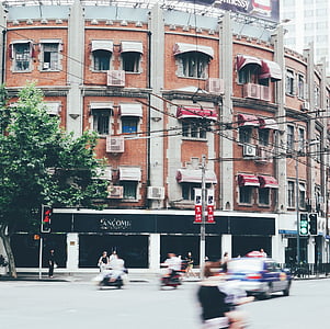 people walking on streets near red building thumbnail