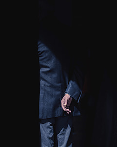 man wearing suit behind shadow thumbnail