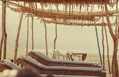 empty plastic chairs near table and beds thumbnail