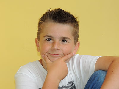 boy sitting near yellow wall doing hand gesture thumbnail