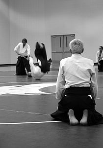 grayscale photo of man kneeling on floor thumbnail