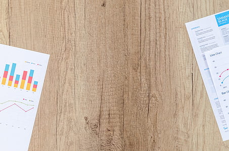 top view of brown wooden surface with two printer papers thumbnail