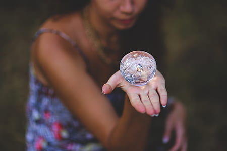 selective focus photo of woman holding clear water ball thumbnail