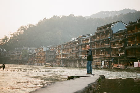 man standing near houses thumbnail