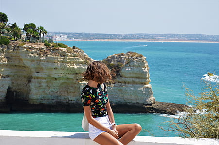 woman sitting on white rock formation near beach thumbnail