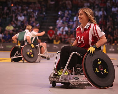 smiling man wearing red and white polo shirt riding game wheelchair inside ring thumbnail
