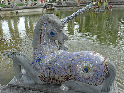 gray and purple mosaic unicorn statue near water thumbnail