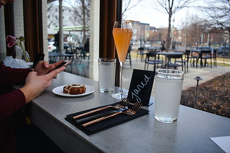 person using smartphone on front of food, drinks, and window thumbnail