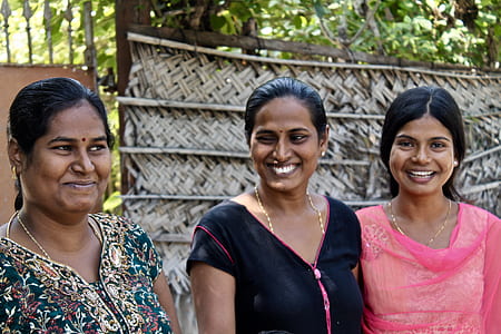 three woman smiling while standing thumbnail