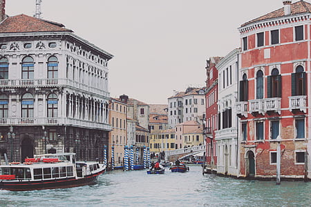 body of water between red-and-white buildings at daytime thumbnail