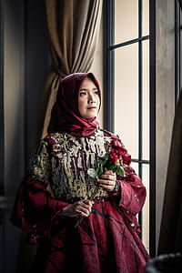 Woman in Pink Gown Holding Red Roses Indoors thumbnail