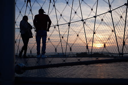 woman and man near mesh fence in sunset thumbnail