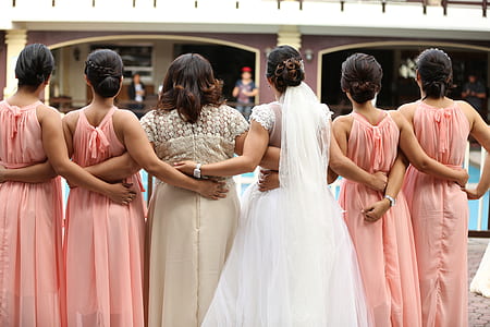 bride and bridesmaids standing side by side near swimming pool thumbnail
