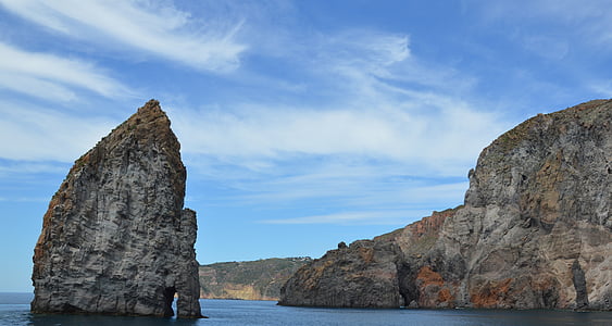 gray stone cliff near body of water during daytime thumbnail