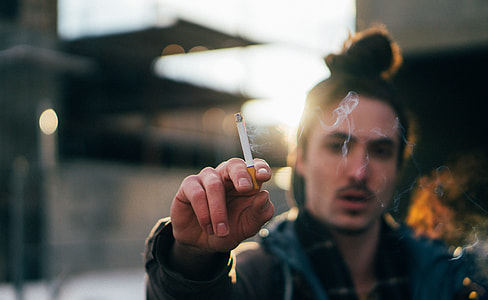 man holding cigarette stick thumbnail