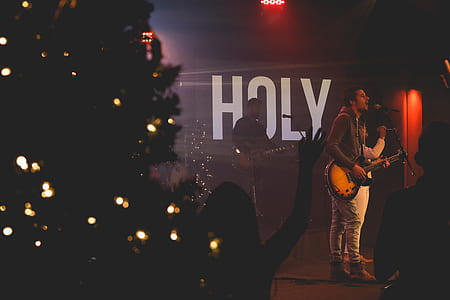 man holding brown and black guitar in front of microphone thumbnail