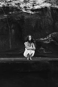 woman sitting beside body of water thumbnail