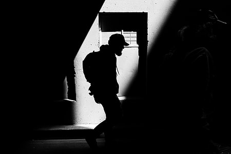 silhouette of man standing beside window thumbnail