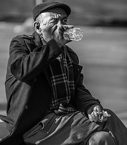 grayscale photo of man drinking from water bottle thumbnail