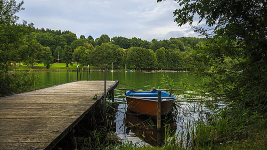 boat parked beside wooden dock thumbnail