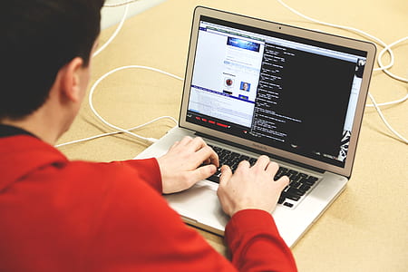 man in red jacket typing on MacBook Air thumbnail