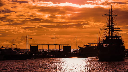 silhouette photography of sailing ship near wharf thumbnail
