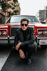 man sitting in front of red car thumbnail