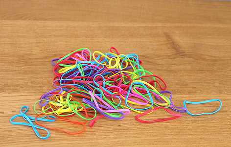assorted-color rubber bands on brown wooden surface thumbnail