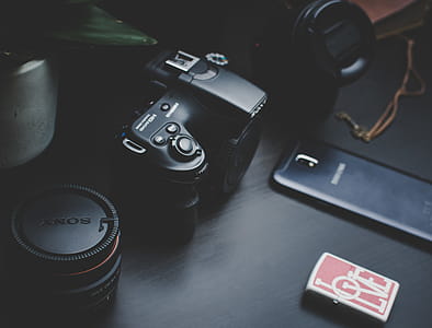 Dslr Camera Beside Samsung Smartphone on Black Surface thumbnail