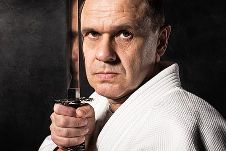man in white top holding katana thumbnail