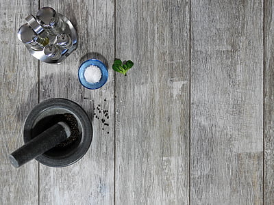 mortar and pestle beside salt and pepper shaker on brown wooden surface thumbnail