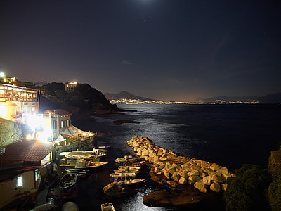 brown houses near seashore at nightime thumbnail
