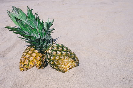 two pineapple fruits on sand thumbnail