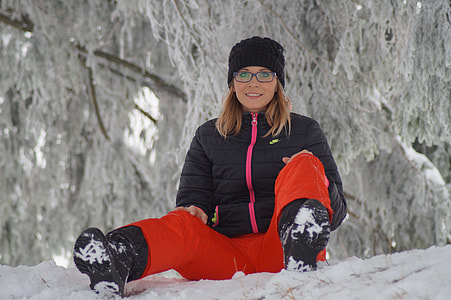 woman in black bubble jacket and red pants sitting thumbnail