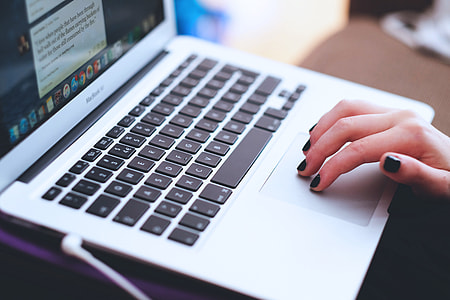 Woman hands working on a laptop computer wearing nail varnish thumbnail