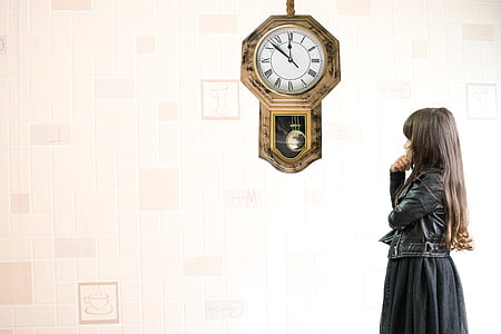 woman wearing black leather jacket standing near pendulum clock thumbnail