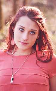 selective focus photography of woman wearing pink short-sleeved top and silver-colored chain necklace thumbnail