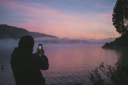 person taking photo of fog on water thumbnail