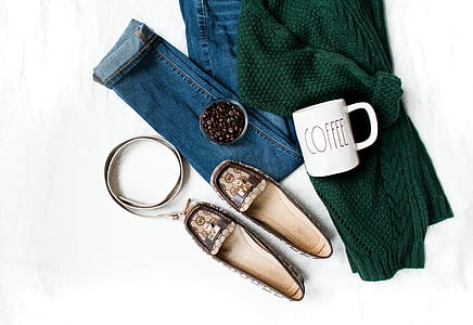 pair of shoes flats beside denim jeans and green cardigan with white coffee mug and leather belt thumbnail