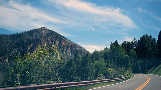 road leading mountain under blue sky thumbnail