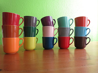 assorted-color ceramic mugs on brown wooden table thumbnail