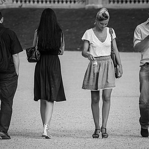 two men and women walking opposite way grayscale photography thumbnail