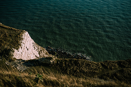 rock mountain near the sea at daytime thumbnail