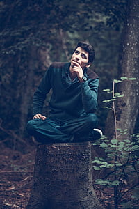 man sitting on tree stump thumbnail
