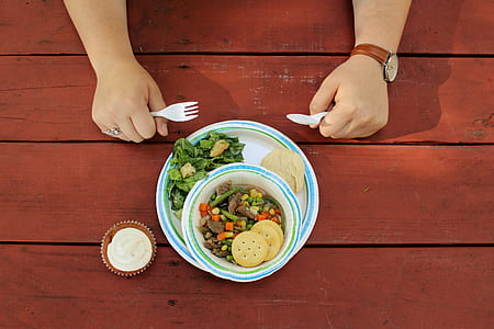 person holding fork and spoon in front of plate and bowl with dish thumbnail