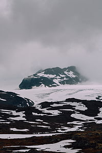 mountain covered in snow under cloudy sky thumbnail