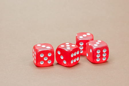 four red dice on brown surface thumbnail