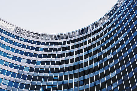low-angle photography of gray building under white sky during daytime thumbnail